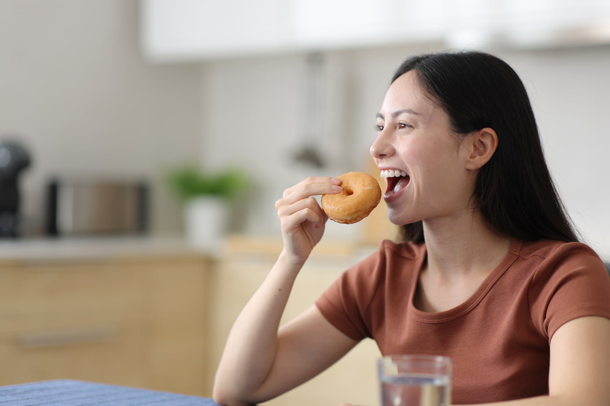 根管治療中に痛みがなくなってドーナツを食べる女性