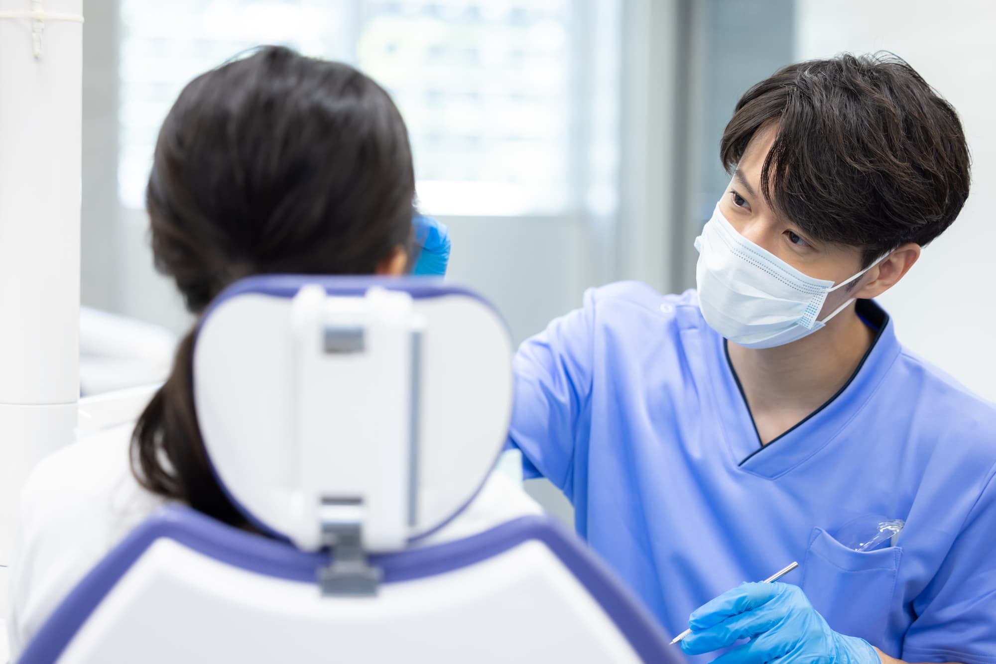 ブリッジ治療をするために患者の口内の確認をする歯科医